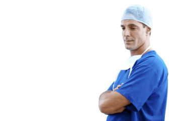 Male doctor standing with his arms crossed in blue scrubs a baby blue hair cover and surgical mask hanging from his neck.