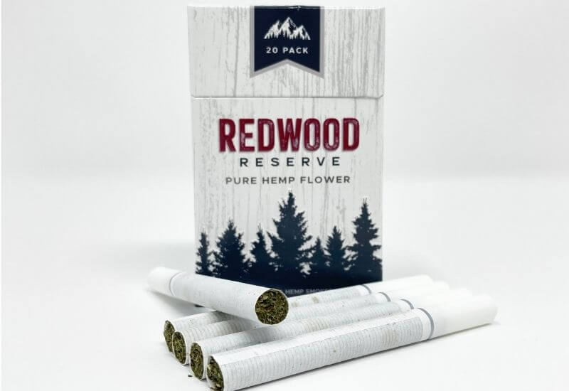 Redwood Reserve original CBD hemp flower cigarette box with five cigarettes laying in front.