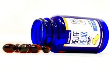 Bottle of CBDistillery softgels laying on its side with a bunch of softgels pouring out.