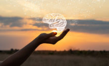 A women's hand with the palm up like it's holding the sun and a hologram of a brain above the sun.