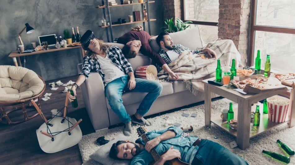 Four guys past out in the living room after a long night partying.
