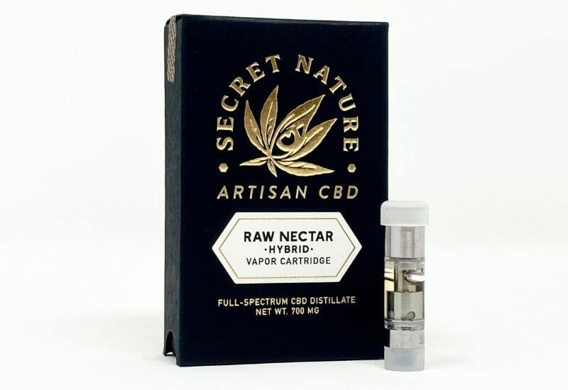 Secret Nature Raw Nectar Full Spectrum CBD vape cartridge standing upright next to its box.