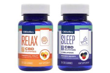 A bottle of CBDistillery tropical fruit and mixed berry CBD gummies standing side by side.
