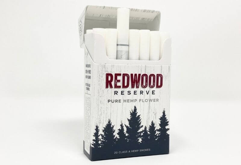 Redwood Reserve original CBD hemp flower cigarette box with the top open and a single cigarette sticking out of the top.
